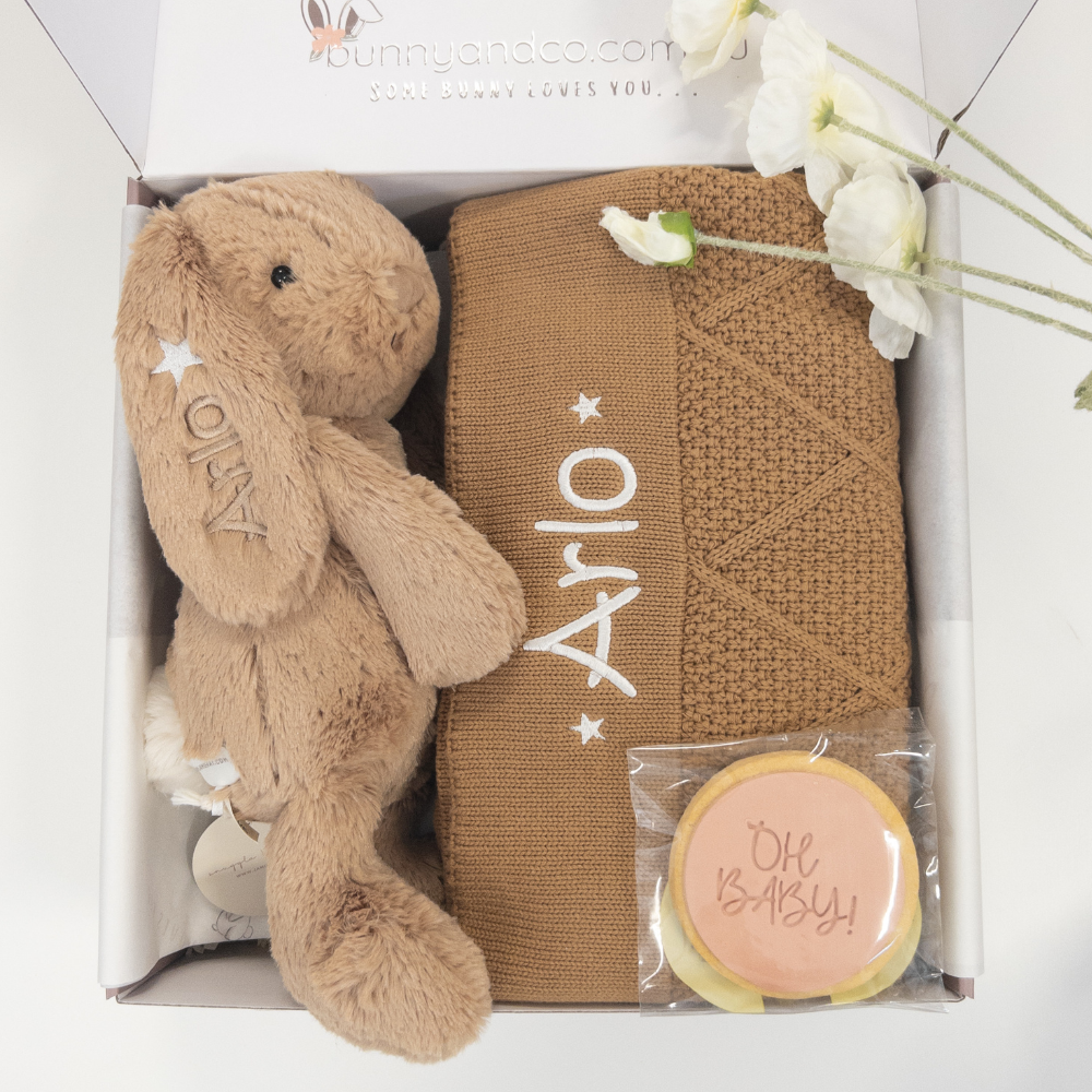 Gift set with personalised snuggle bunnies plush toy bunny, baby diamond knit blanket, and cookie in a box on a white background