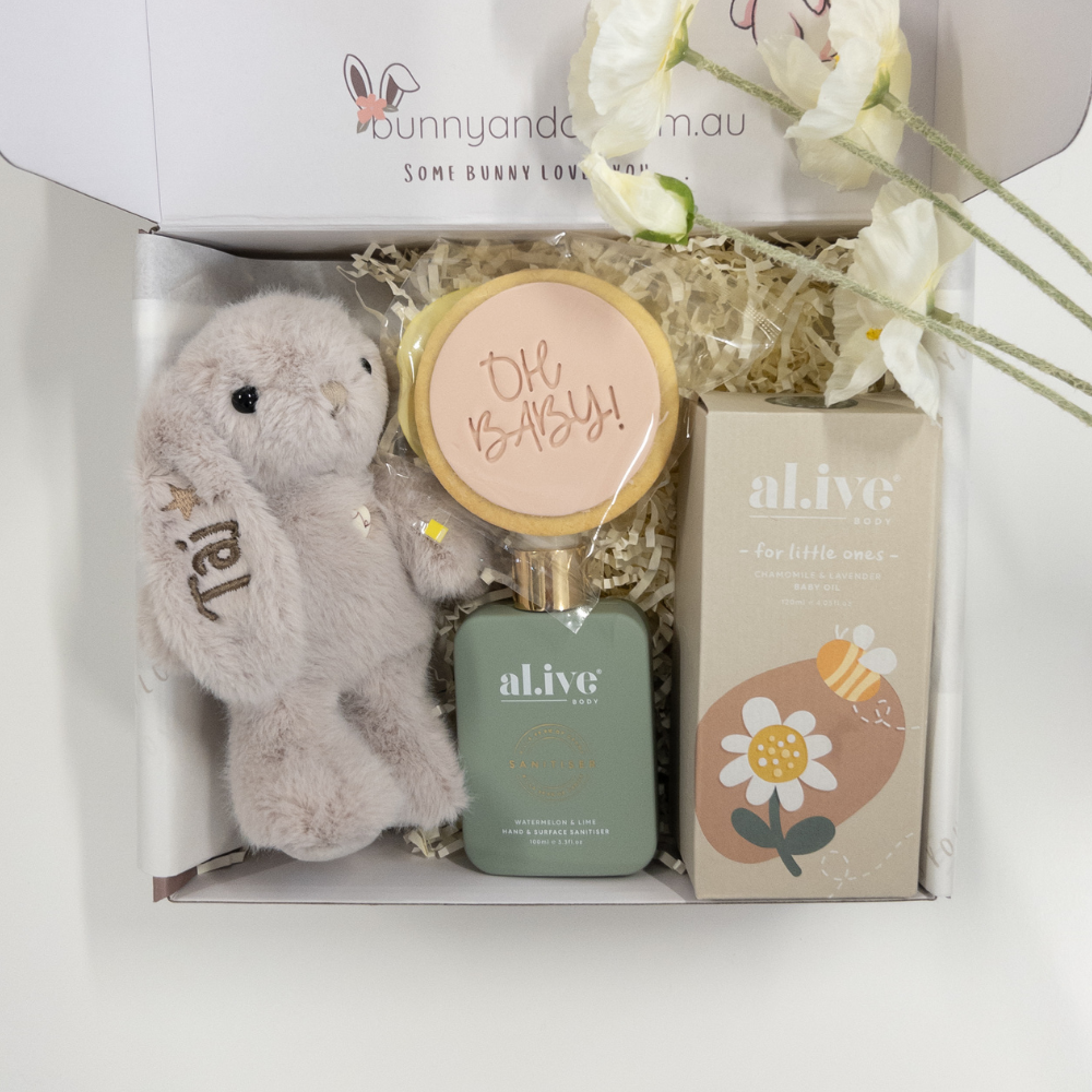 Baby gift set with personalised plush toy, cookie and al.ive body products in a box, featuring 'alive' brand.
