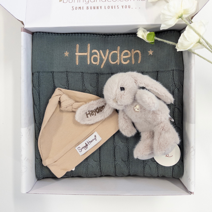 Baby gift set with forest green cable knit blanket, beige beanie, and plush personalised bunny in a box.