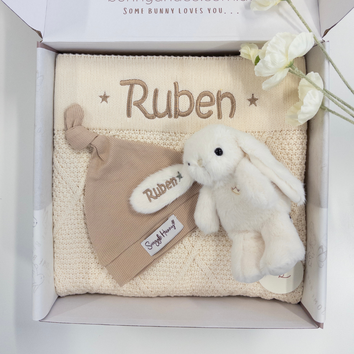 Baby gift set with knitted blanket, hat, and plush toy in a box, personalized with 'Ruben'.