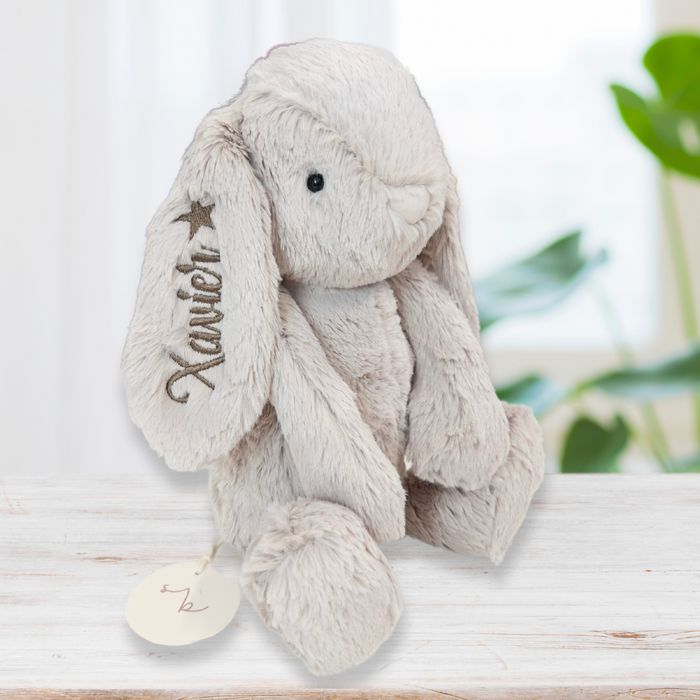 A beige Jamie Kay Snuggle Bunnies plush toy bunny rabbit personalized  with a name and star embroidered on one ear