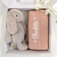 Plush rabbit toy and pink blanket with embroidered names in a box, branded 'bunnyandco.com'.