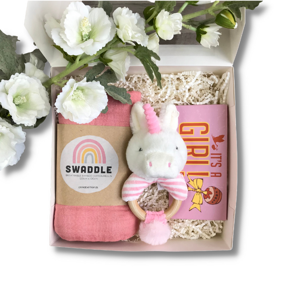 Newborn baby gift hamper containing pink swaddle, chocolate and unicorn rattle